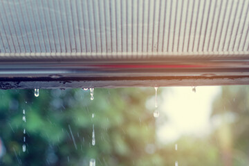 Water flowing from the roof due to heavy rain, drops of heavy rain when we looking from building to...