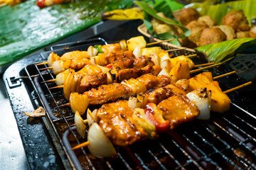 Asian food. Different mini barbecue counter at night street food market.