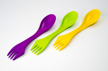 Tourist plastic fork spoon in different colors, photographed large on a white background.