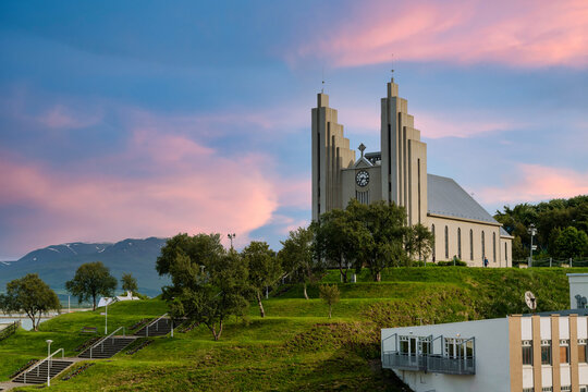Akureyrarkirkja Lutheran Church This is an important and popular landmark of Akureyri city in Northern Iceland, in the evening sky blue vanilla. In the summer there are trees and green grass.