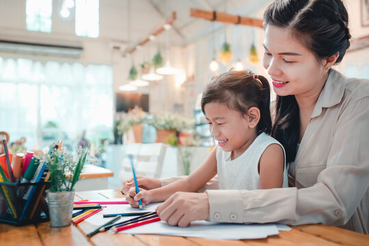 Happy family. Asian moms and children do activities at home. Mother is going to teach children to write books and study online at home. During the virus epidemic, Covid-19