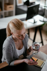 Beautiful businesswoman in office. Tired woman having headache while working.	
