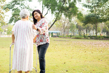 Help and care Asian senior or elderly old lady woman use walker with strong health while walking at park in happy fresh holiday.