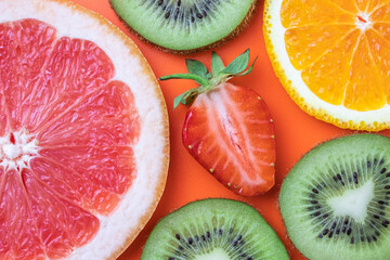 Citrus fruit texture, summer background, orange pattern. Slices of fresh grapefruit, strawberry, kiwi and tangerine. Creative design.