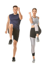 Sporty young couple training on white background