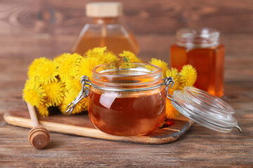 Composition with sweet dandelion honey on wooden background