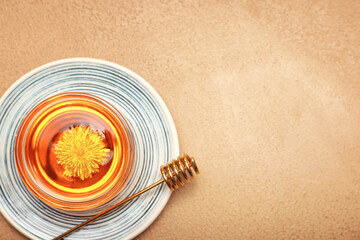 Bowl of sweet dandelion honey on color background