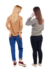 Back view of two young woman photographed on a mobile phone in sweater.