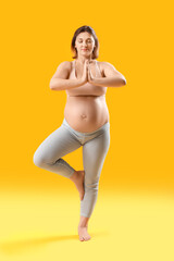 Young pregnant woman practicing yoga on color background