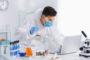 Scientist studying samples of soil in laboratory