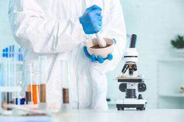 Scientist studying samples of soil in laboratory