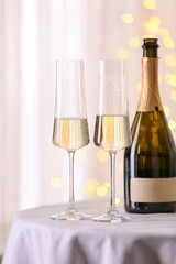 Glasses and bottle of tasty champagne on table