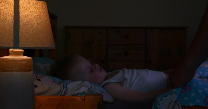 Loving father kissing his baby boy.Father kissing his baby boy forehead while his sleeping and holding hands. Parent love.