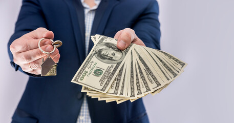Male hands  holding US dollars bills and house key isolated