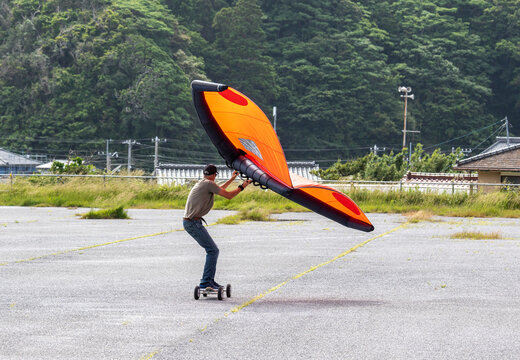 Wing Surfer, a man on a skateboard flying a wing, foil, sky wing, wing surf, it is a new extreme sport becoming popular all over the world, A new mode of transport that is fun. Katsuura, Chiba, Japan