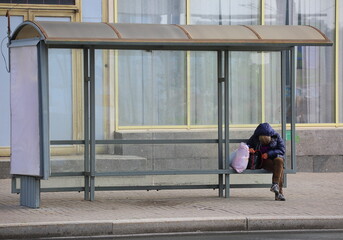 passenger sleeps at the bus stop