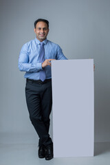 Happy attractive businessman holding blank board as copyspace