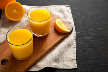 Healthy Orange Juice on a black background, low angle view. Copy space.