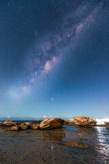 Milky way view over the rocky coastline of Coalcliff, NSW, Australia.