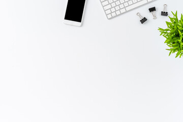 Overhead shot of computer keyboard with business accessories on white desktop. Modern workspace concept. Flat lay