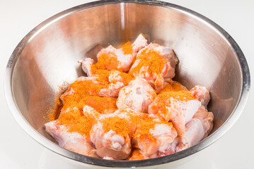 Raw chicken wings in a Stainless steel bowl unprepared with spices.