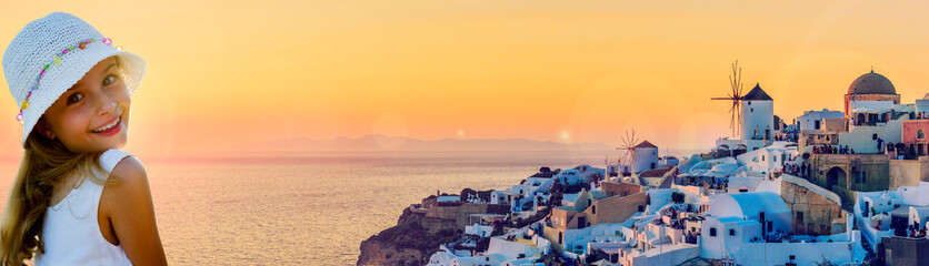 Girl with amazing view with white houses in Oia village on Santorini island in Greece at suset.