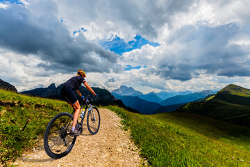 Fototapeta na wymiar Cycling outdoor adventure in Dolomites. Cycling woman in Dolomites landscape. Woman cycling MTB enduro trail track. Outdoor sport activity.