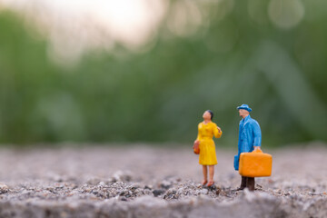 Miniature people , Traveler holding a handbag standing in the park