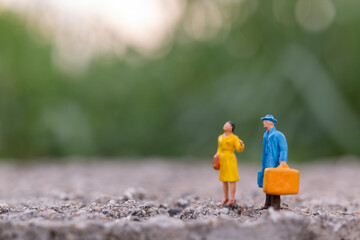 Naklejka premium Miniature people , Traveler holding a handbag standing in the park