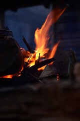 Detailaufnahme eines brennenden Lagerfeuer mit rot gelber Flamme und Holz