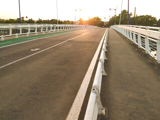 Personas caminando sobre Pasarela de La Cartuja Sevilla al atardecer