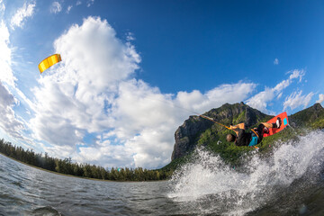 professional kiter makes the difficult trick on a beautiful background of spray and beautiful...