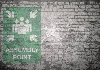Grunge decayed faded brick wall background with assembly point sign with copy space for own text