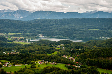 Fototapeta premium Panoramic view of the valley with houses, a river, mountains and clouds