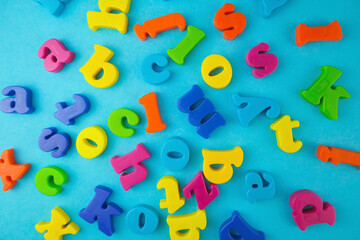 Plastic colourful alphabet letters on the blue background.