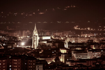 Fototapeta na wymiar Night view of a cathedral surrounded by buildings in the middle of a city in northern of Spain
