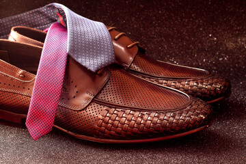 Brown men's shoes and ties on a black background. Shoes with a weave.