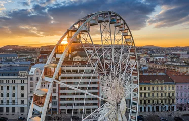  Budapest, Hungary - Aerial view of the famous ferris wheel of Budapest with Buda Castle Royal Palace and an amazing golden sunset and sky. The wheel is totally empty due to the Coronavirus disease © zgphotography