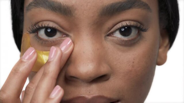 Close-up portrait shot of an attractive girl with a gold patch under the eye. Isolated, on white background