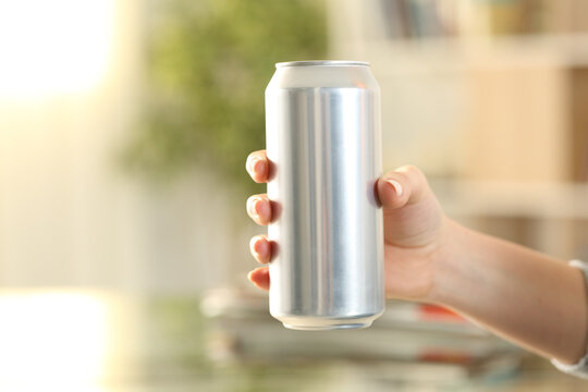 Woman hand holding a soda drink can at home