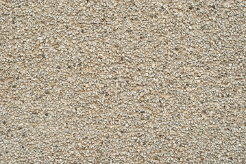 The texture of the wall is made of small yellow, black and white stones.