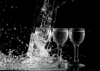 glasses with water with splashes on a black background