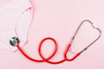 Pink underpants and red stethoscope  isolated on pink background.Woman hygiene, Concept of sanitary pad,critical days, menstruation,health care