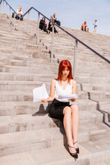 Young redhead business woman in formal outside