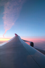 airplane flying over sunrise clouds