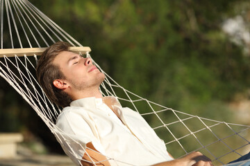 Relaxed man resting lying on a hammock outdoors