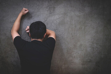 Young man close up portrait worried sad and stressed standing show your emotions fist punch smash to wall dark background. Depressed 