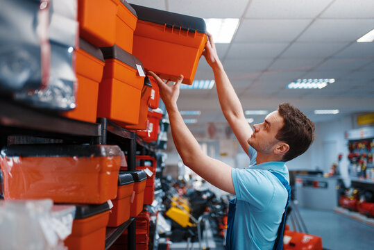 Male employee choosing toolbox in tool store