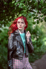 A girl with pink hair on the street among the trees