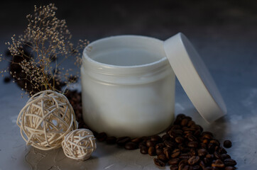 cosmetic jar with coffee beans on background